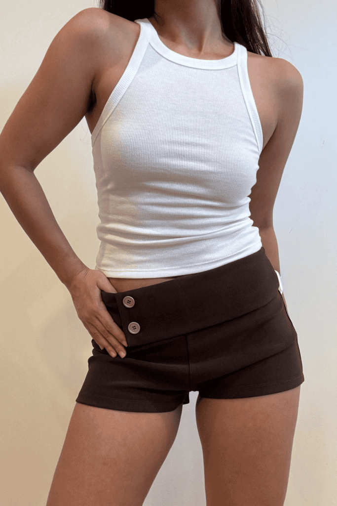 Woman in white tank top and shorts.