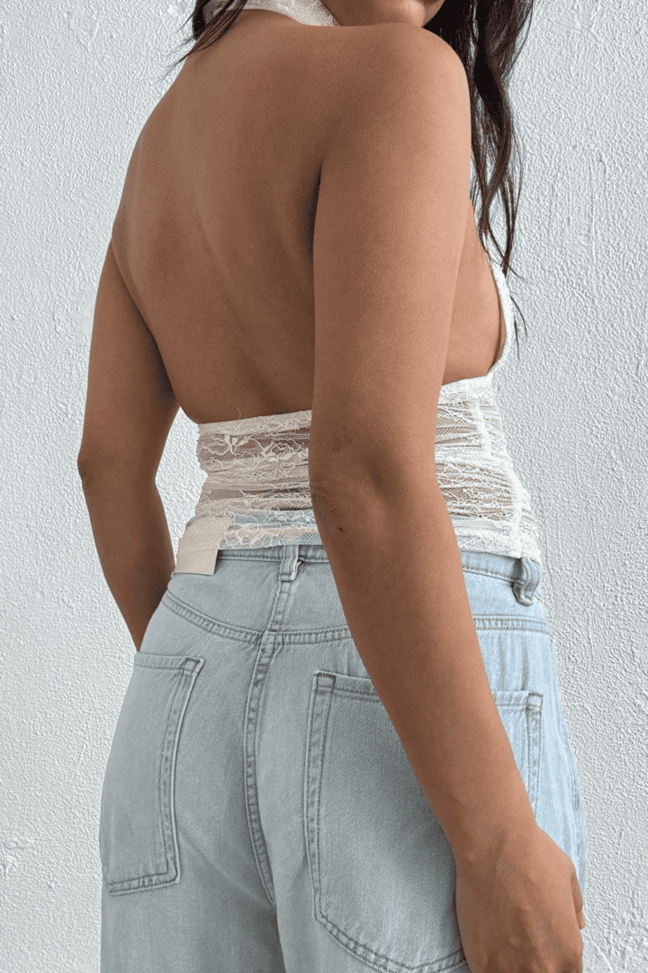 Woman in lace top and jeans.