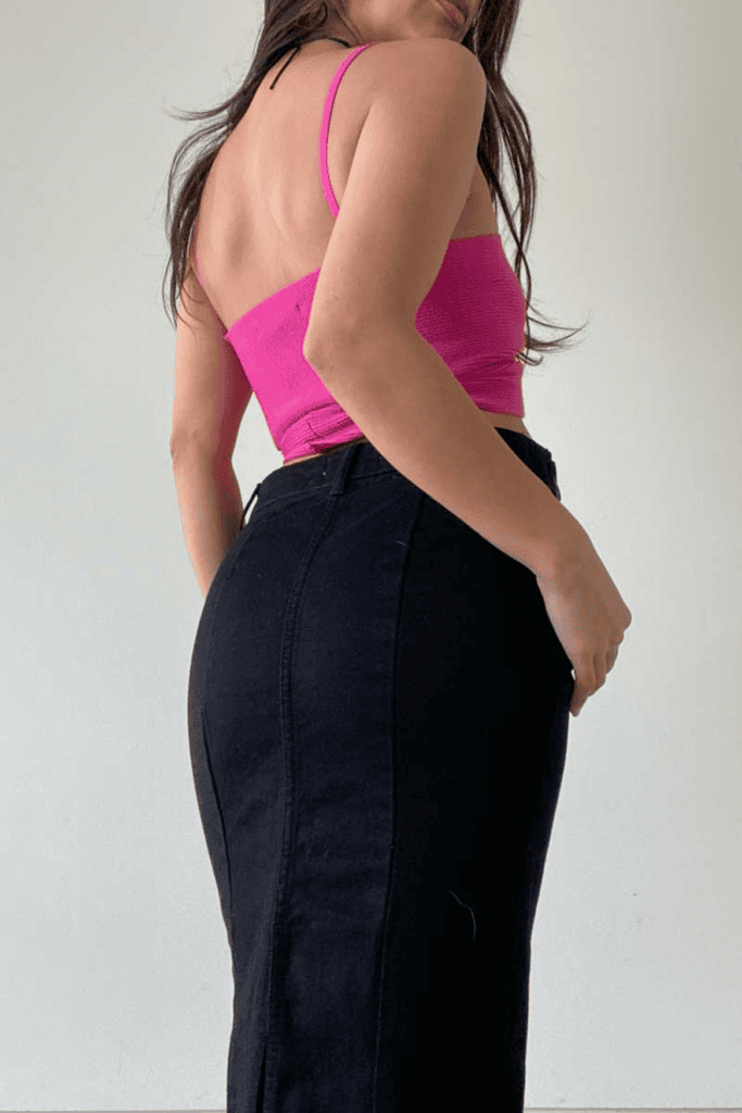 Woman in pink top and black skirt.