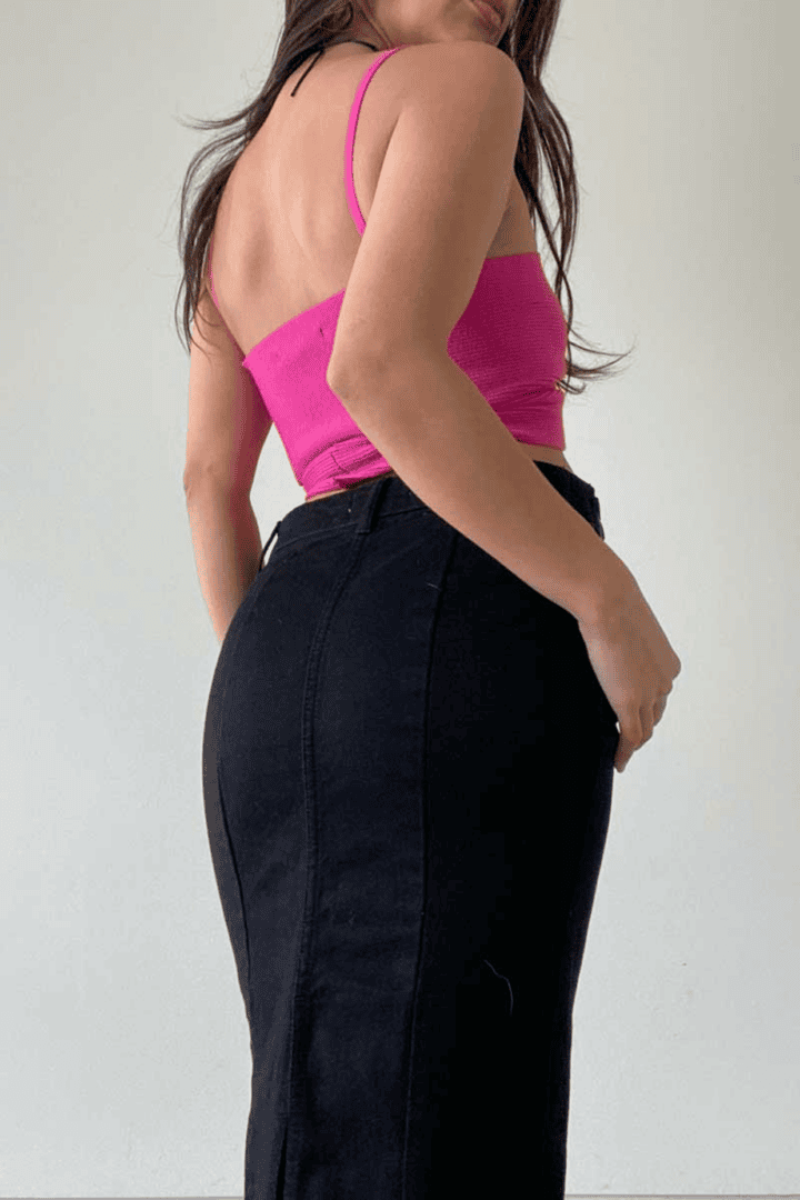Woman in pink top and black skirt.