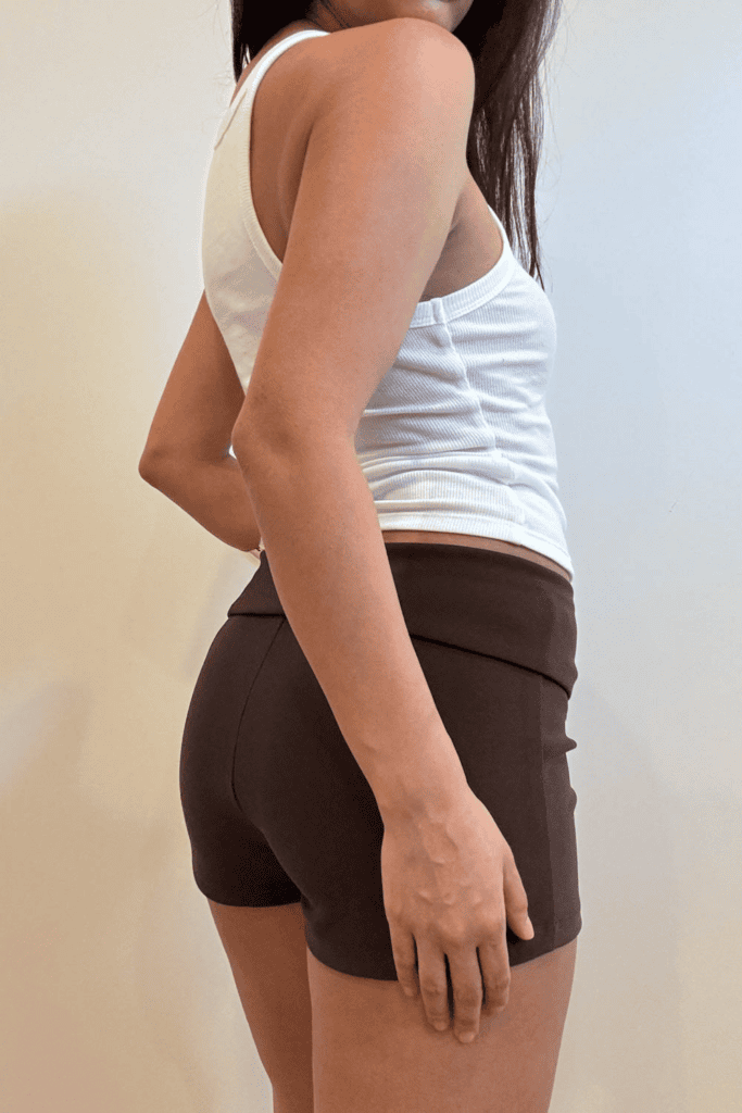 Woman in white tank top and shorts.