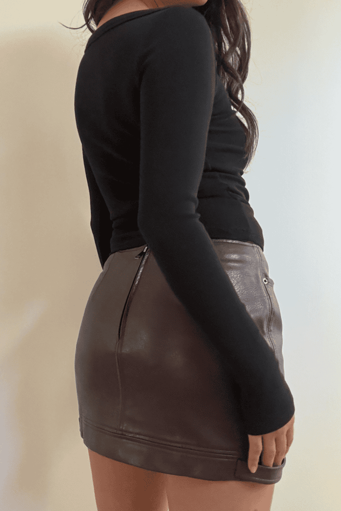 Woman wearing black top and leather skirt.