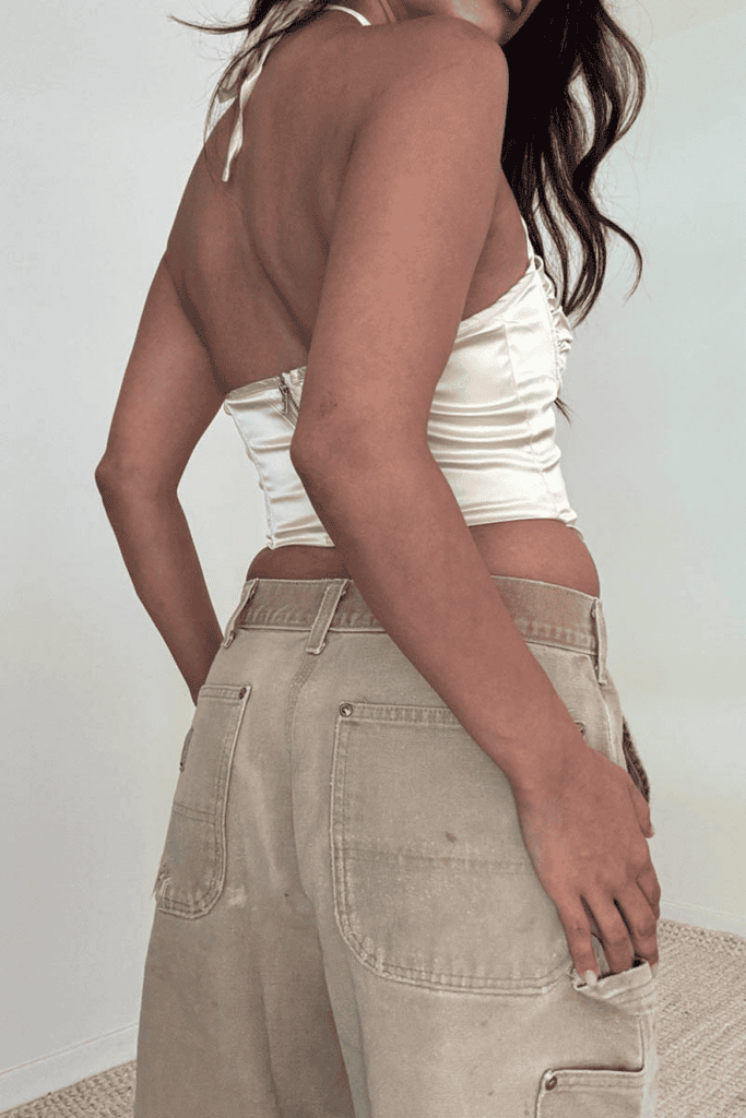 Woman in white top and beige pants.