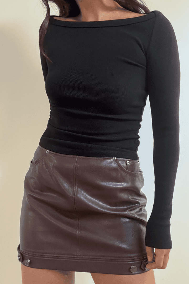 Woman in black top and brown skirt.
