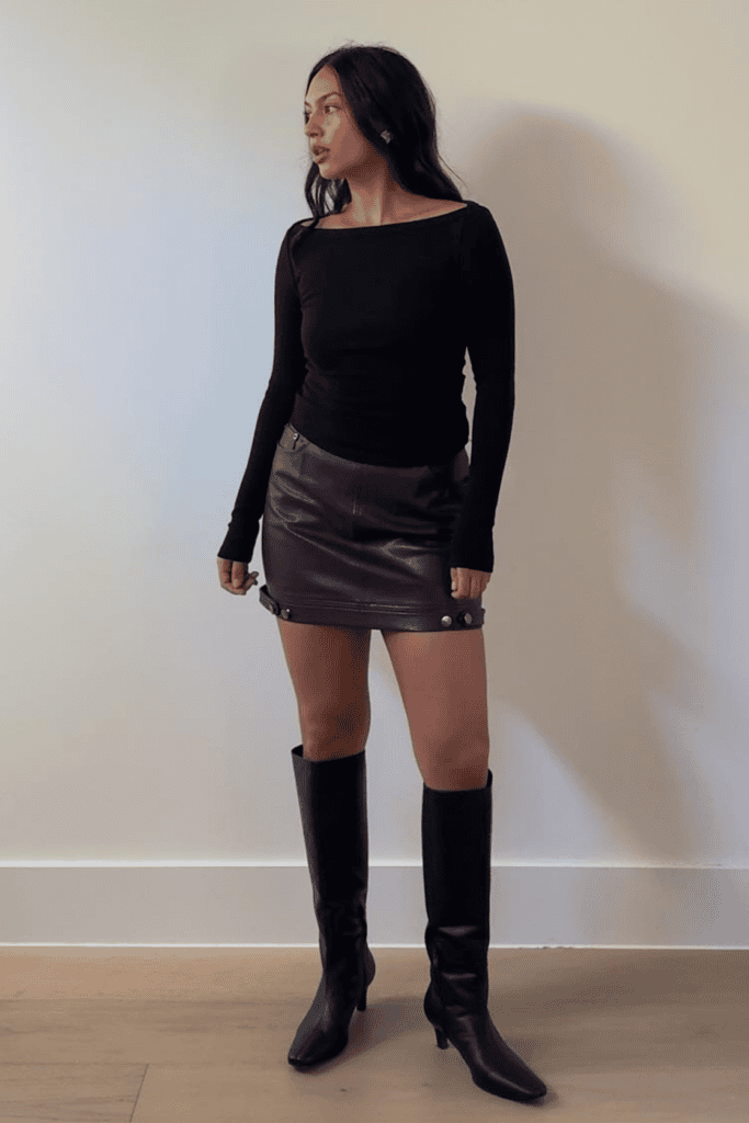 Woman in black top and skirt outfit.