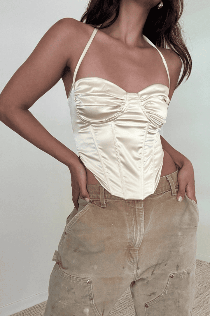 Woman in satin top and cargo pants.