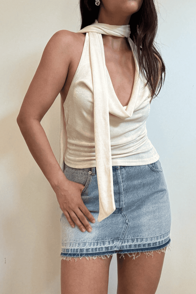 Woman in stylish top and denim skirt.