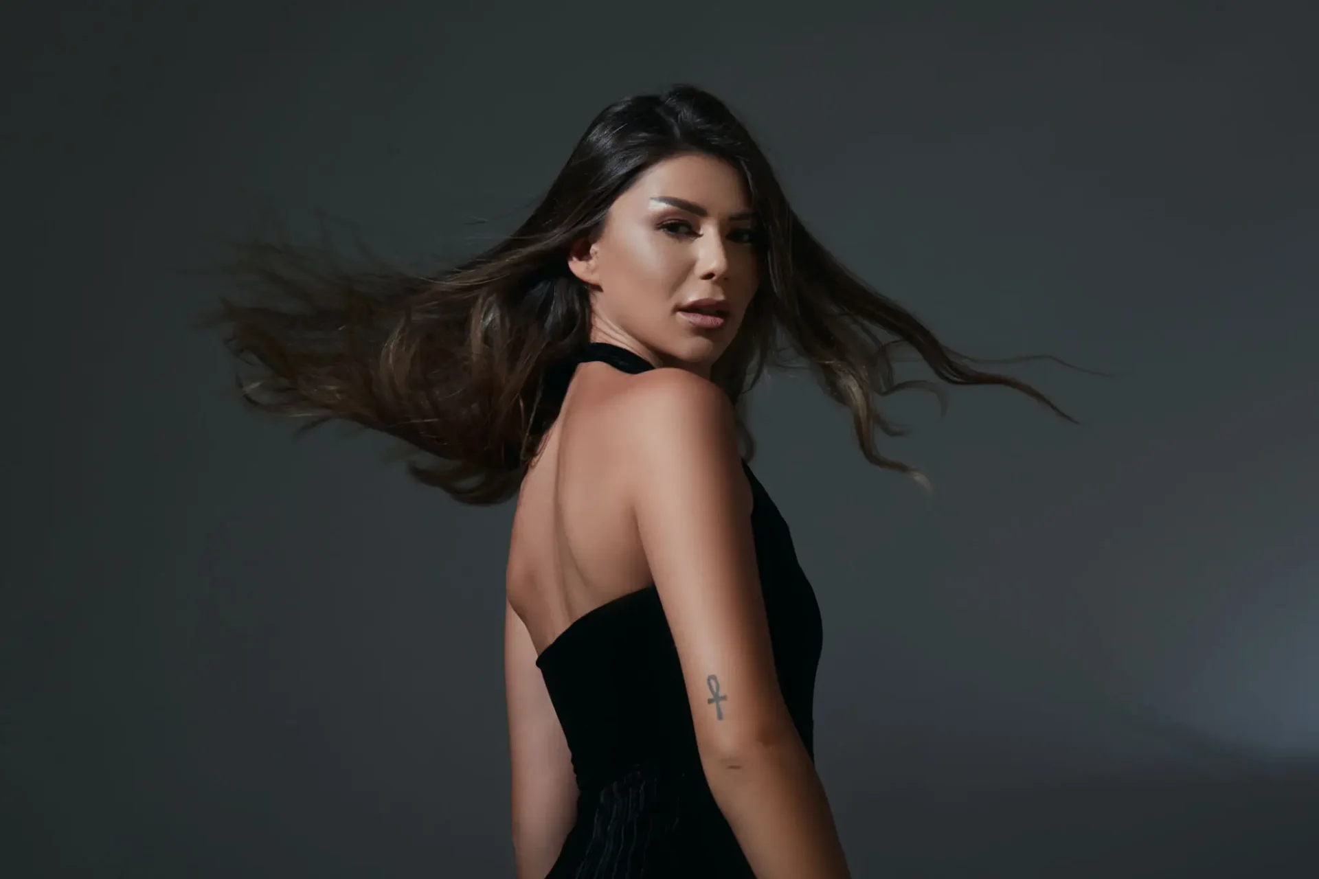 Woman in black dress with flowing hair.